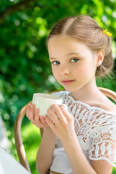 Little girl with white cup outdoor. — Stock Photo, Image