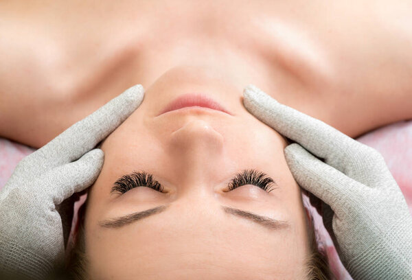 Rejuvenating facial treatment. Woman getting lifting therapy face massage in a beauty SPA salon. Exfoliation, Rejuvenation And Hydratation. Close up, selective focus.