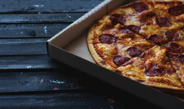 Siyah ahşap arka planda pizza. Seçici odak.