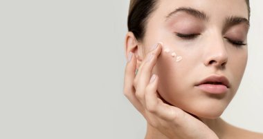 Mükemmel ciltli ve doğal makyajlı güzel bir kadın tropik yeşil yaprakların önünde eğreltiotu ile poz veriyor. Yüzü ve vücudu ıslak saçlarıyla genç bir manken. Spa, sağlık, vücut bakımı ve cilt bakımı. Yaklaş, seçici odaklanma.