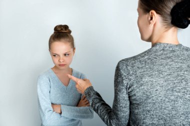 Üzgün bir suratı olan küçük bir kız annesine sırtını döndü. çocuk ve ebeveynlerin sorunları.