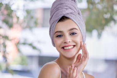 Kafasında havlu olan genç ve güzel bir kız evde cildiyle ilgileniyor. Taze derisi ve uzun kirpikleri olan güzel bir model. Spa ve Sağlık, Cilt Bakımı Konsepti.
