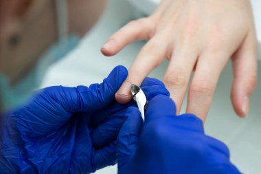 Manikürcüde kadın eli klasik kesim manikür yaptırıyor. Tırnak bakımı. Manikür, pedikür ve SPA. Yaklaş, seçici odaklanma.