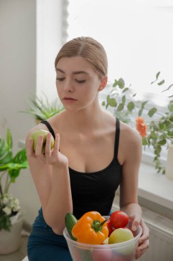 Elma tutan güzel bir genç kız. Sebze ve meyve. Sağlıklı gıda, diyet ve fitness konsepti. Organik yiyecekler.