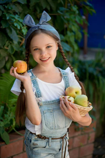 Nettes Lächelndes Kleines Mädchen Hält Korb Mit Äpfeln Auf Dem — Stockfoto