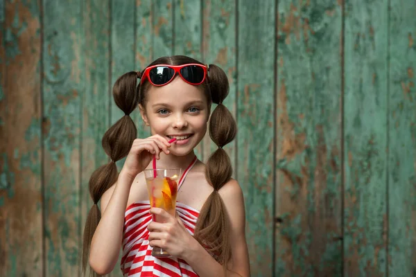 Schattig Klein Meisje Drinkt Limonade Voor Oude Landelijke Houten Achtergrond — Stockfoto