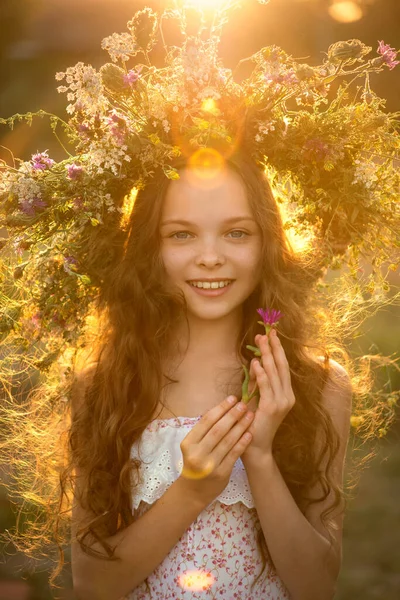 農場の牧草地に花の花輪を持つかわいい笑顔の女の子 愛らしい小さな子供の屋外の肖像画 — ストック写真