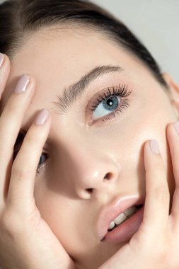 Temiz ciltli güzel bir genç kadın. Doğal çıplak makyajlı, manikürlü, dokunaklı el ve güzellik modeli portresi. Spa, cilt bakımı ve sağlık. Kapat, arkaplan, kopyala.