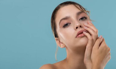 Taze, kusursuz cilde sahip genç ve güzel bir kadın nemli cildine önem verir. Doğal makyajlı bir güzellik modeli portresi. Spa, cilt bakımı ve sağlık.