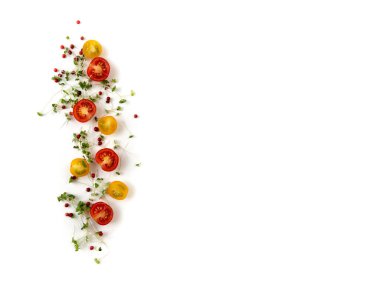 Kırmızı ve sarı kiraz domateslerinin bileşimi mikro yeşiller ve beyaz arka planda pembe biber, izole edilmiş..