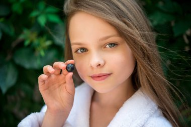 Tatlı küçük kız yabanmersini ve ahududu yiyor. Çocuk yiyor. B, A, C vitaminleri. Yakından, sığ derinlikten..