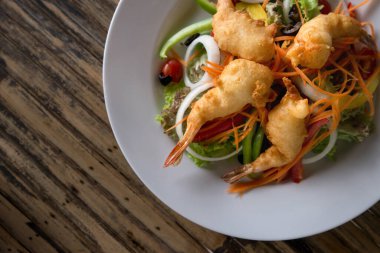 Marul yapraklı bir tabakta kızarmış karides. Asya tarzı