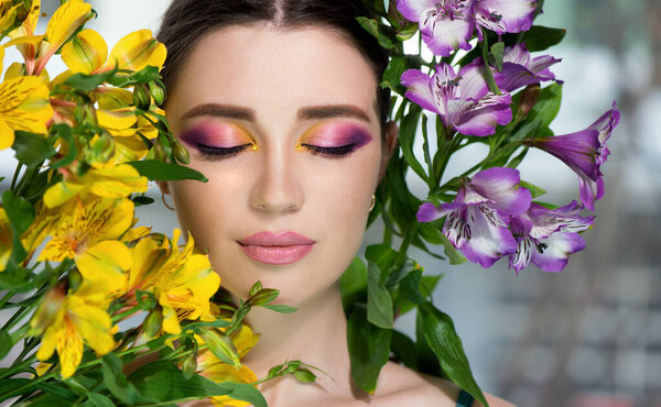 Модель с творческим профессиональным макияжем с фиолетовым и желтым цветом и цветом. SPA и концепция wellness, body care и skincare.