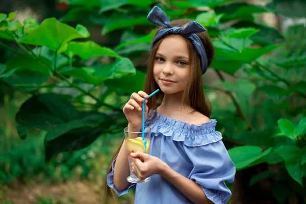 Söt Liten Flicka Dricker Lemonad Framför Gröna Blad Bakgrund Grabben — Stockfoto