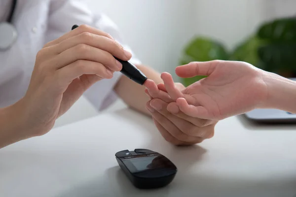 A doctor does a diabetes test for a child. Close-up hand of a girl taking a blood test for sugar. Blood glucose meter. Close up, selective focus.