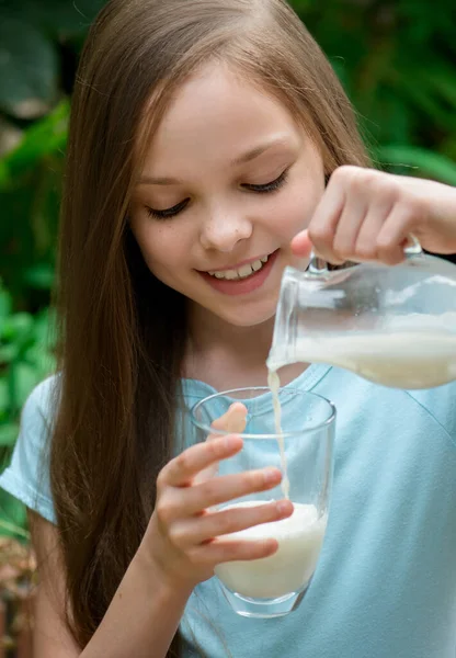 Cute girl drinking milk. Little young lady holds glass of milk. Organic farm products.