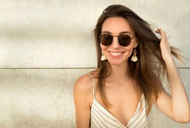 Uzun saçlı, güzel bir genç kadın. Gülümseyen güzel bir kızın olumlu duygusal portresi..