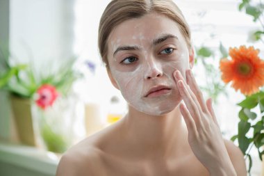 Yüzü kozmetik cilt köpüğü, jöle ya da sabunla temizleyen güzel bir genç kız. Kadın hame SPA prosedürleri.