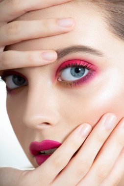Mükemmel ciltli, uzun kirpikli ve parlak pembe makyajlı güzel bir genç kadın yüzü. Renkli profesyonel makyajlı moda güzellik modeli portresi. Macro, seçici odaklanma.