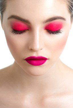 Kapalı gözlü, mükemmel ciltli, uzun kirpikli ve parlak pembe makyajlı güzel bir kadın yüzü. Profesyonel makyajlı ve uzun kirpikli model portresi. Spa, sağlık, makyaj ve cilt bakımı.