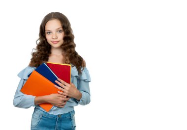 Mutlu genç kız öğrenci elinde renkli kitaplar ve not defterleri tutuyor. Gülümseyen liseli kız beyazların arasında. Eğitim kavramı, okuma, okula dönüş..