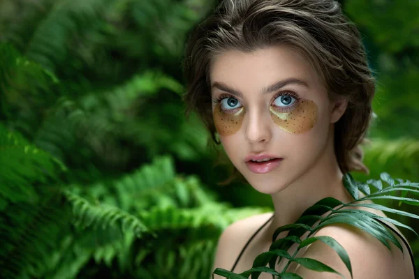 Mulher Bonita Aplica Máscara Olho Verde Dourado Com Folha Tropical — Fotografia de Stock