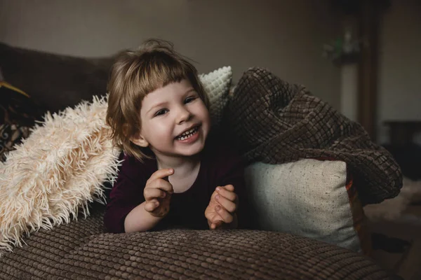 Urocze Emocjonalne Dziecko Uśmiecha Się Kanapie Domu — Zdjęcie stockowe