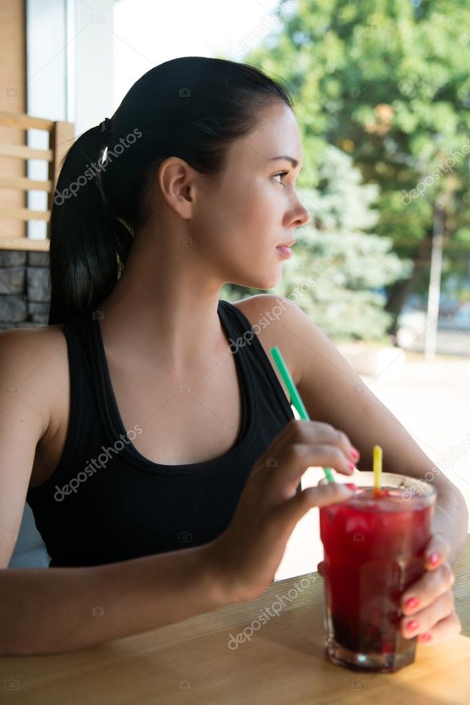 Young European  woman drinking lemonade  in an cafe