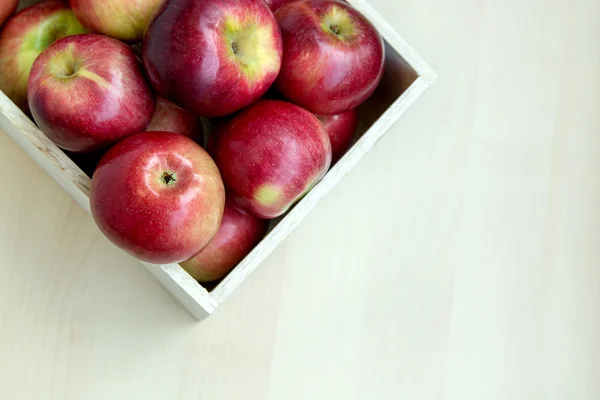 Jabłka w drewniane pudełko na stole, z bliska — Zdjęcie stockowe