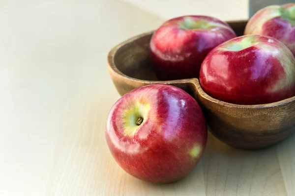 Äpfel im herzförmigen Holzteller auf dem Tisch, Nahaufnahme — Stockfoto