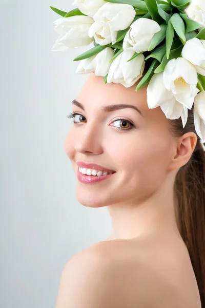 Mladá žena s květinami ve vlasech — Stock fotografie