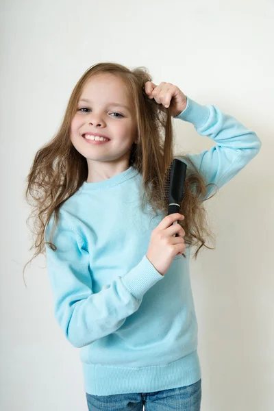 Klein meisje haar haren kammen — Stockfoto