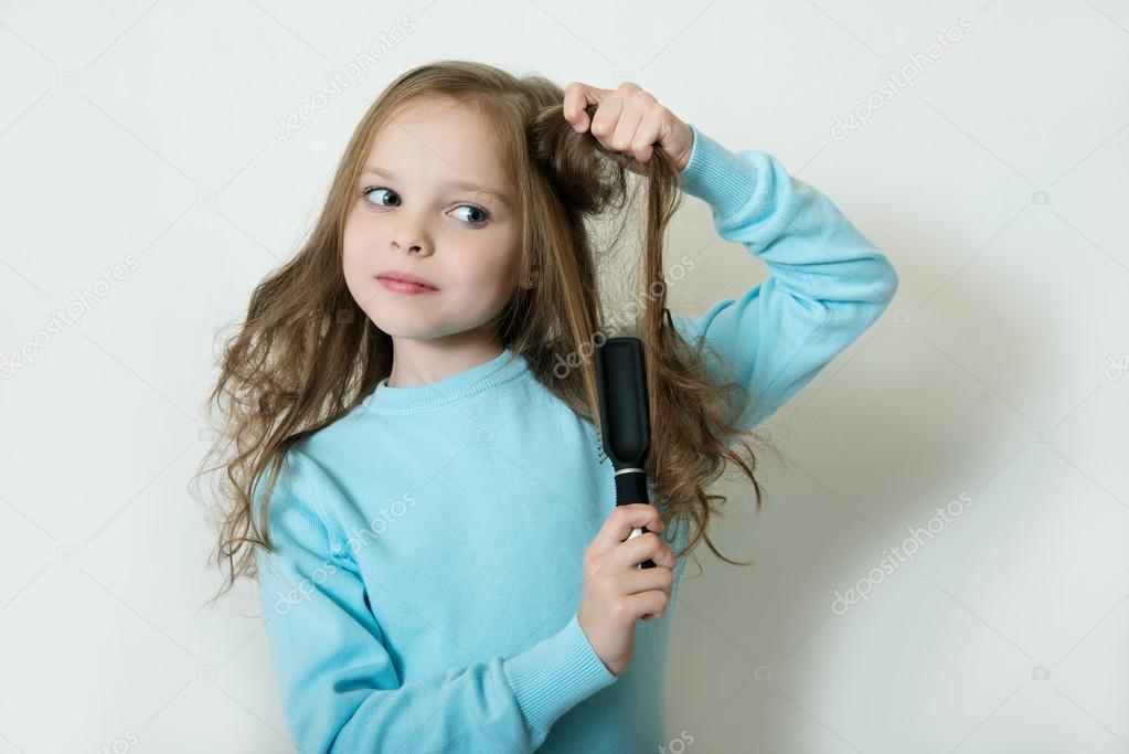 Little girl combing her hair Stock Photo by ©jutar 65465309