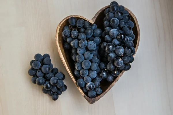 Uvas en forma de corazón plato de madera — Foto de Stock