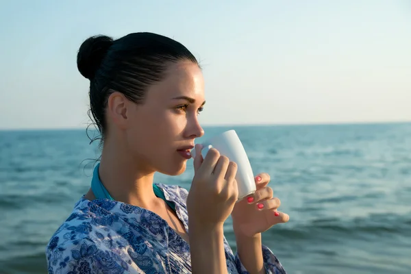 Beautiful woman with white mug at the sea — Stock Photo, Image