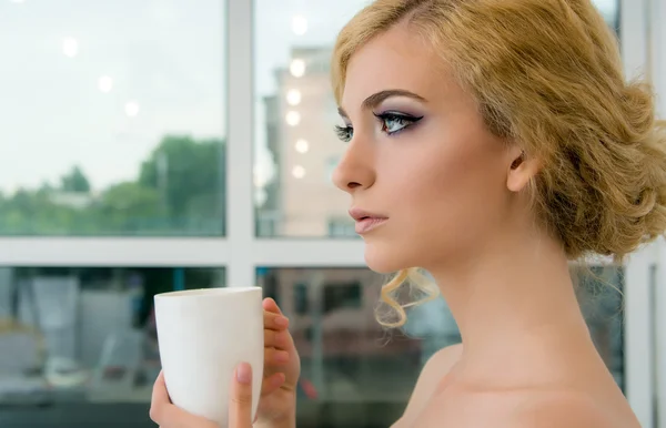 Femme avec tasse devant la fenêtre — Photo