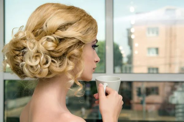 Mujer con taza delante de la ventana — Foto de Stock