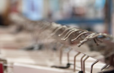 Giysiler bir mağazanın rafında asılı. 