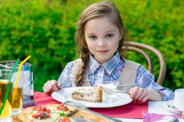 yemek masası tarafından oturma ve yemek sevimli küçük kız 