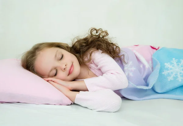 Красивая маленькая девочка спит в своей постели — стоковое фото