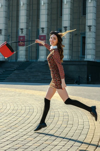 Beautiful brunette girl in stylish dress jumps — Stock Photo, Image
