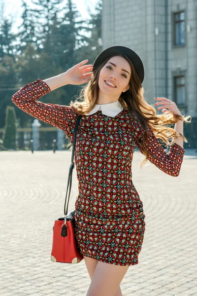 Mooie brunette meisje in stijlvolle jurk springt — Stockfoto