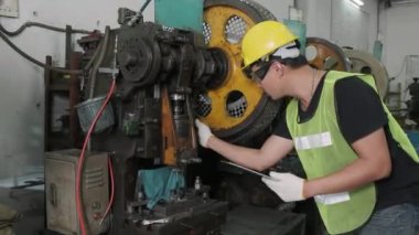 Asyalı bir erkek mühendis ya da işçi kullanmadan önce makineleri kontrol eder ve tamir eder. sanayi ve mühendislik kavramı. 