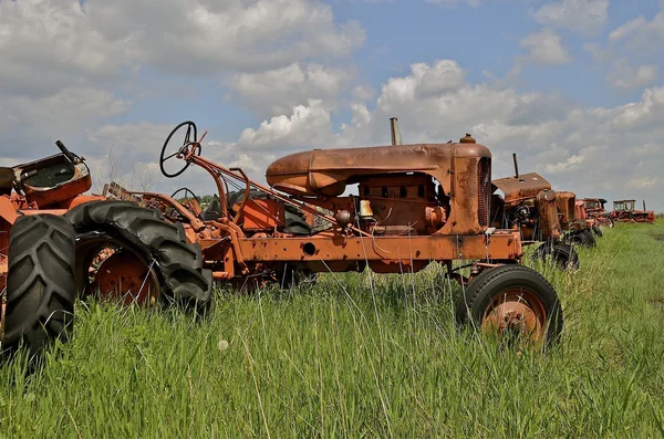 Old orange tractors in a junkyard — Stock Photo, Image