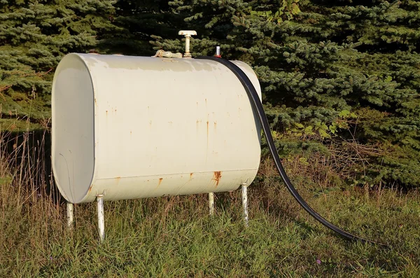 Vieux réservoir d'essence avec tuyau dans la cour arrière — Photo