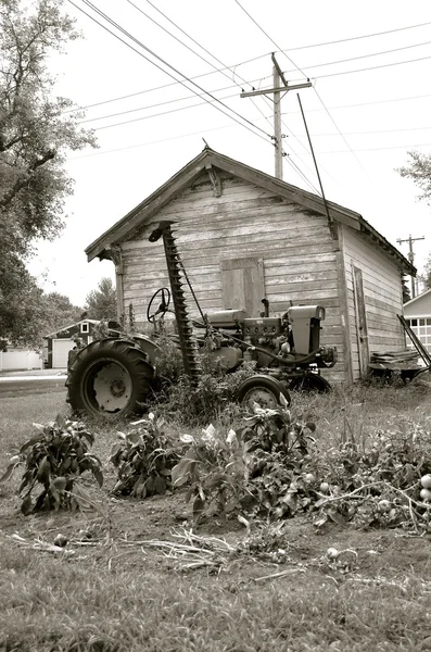 Viejo tractor en una ciudad de alambres de alta línea — Foto de Stock