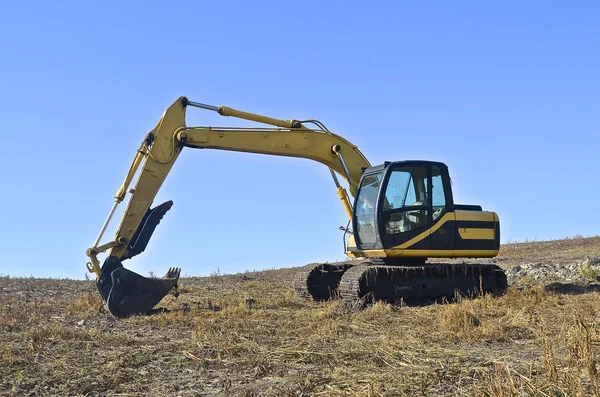 Backhoe estacionado em um campo — Fotografia de Stock