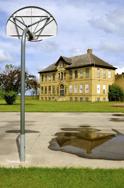 농구 코트에 반영 하는 오래 된 학교 건물 — 스톡 사진