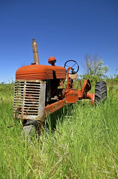 Old orange tractor with a crank — Stock Photo, Image