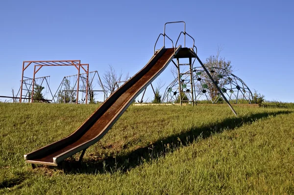 Oude gladde glijbaan op een school werf Speeltuin — Stockfoto